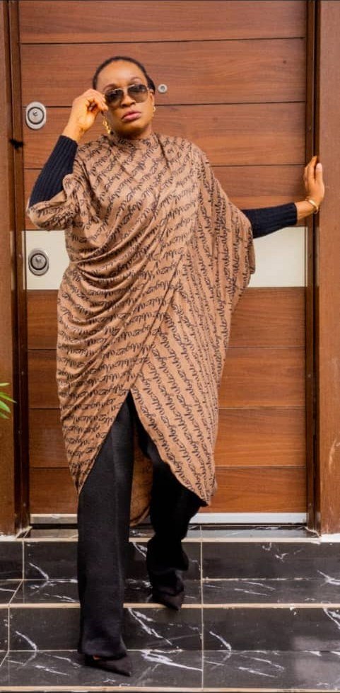Ìtura draped tunic in brown script print, worn with black wide-leg trousers